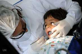 Un dentista revisa la dentadura de un niño. / UN