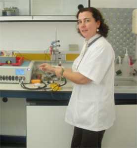 María J. García muestra el fotoelectrodo, de color transparente debido al dióxido de titanio.