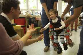 Álvaro, de cinco años y afectado por atrofia muscular espinal, camina hacia sus padres durante una prueba del exoesqueleto. / Joan Costa – CSIC